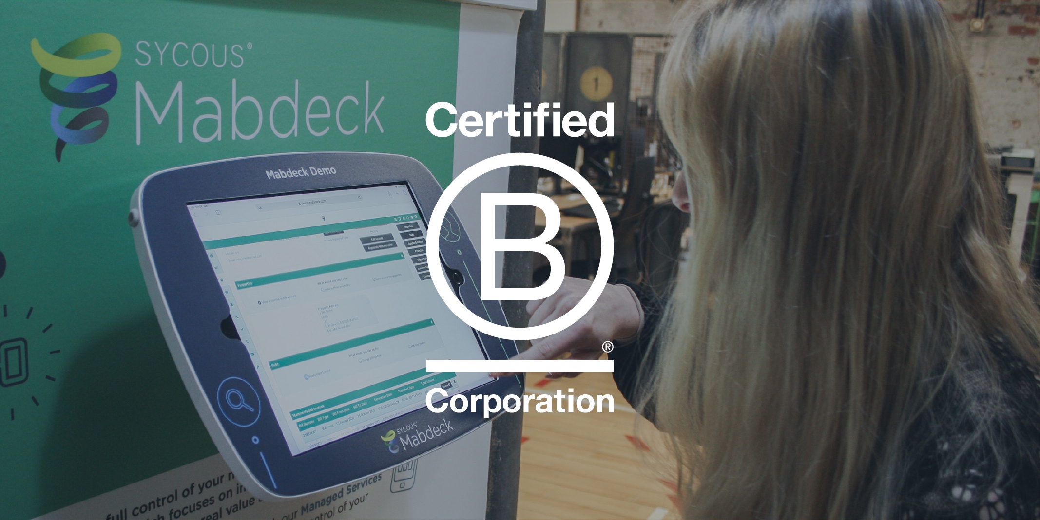 Sycous B Corp logo on office Mabdeck software demonstration